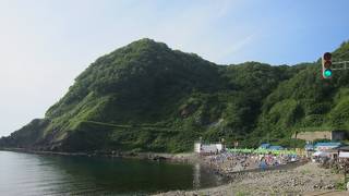 水がエメラルドグリーンに輝く積丹半島の海水浴場