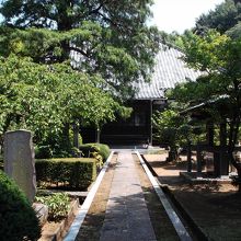 植木と石碑、正面が本堂