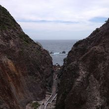 鉈で削られたような岩の向こうに温泉がある。