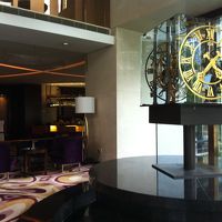 エントランスに有る印象的な時計とその奥がカフェラウンジ