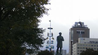 紅葉が始まった樹木の側に立つケプロン像