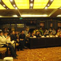 忘年会の余興を鑑賞する従業員たち。右端が社長さん。