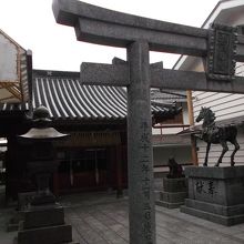 鳥居越しに馬の銅像