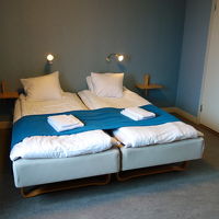 清潔感のあるベッド。床はコンクリート打ちっぱなしみたい。