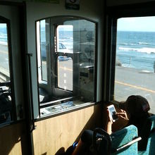 道路を挟んですぐそばに湘南の海が広がる車窓です。