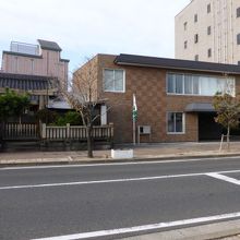 右の茶色の建物の場所が跡地です