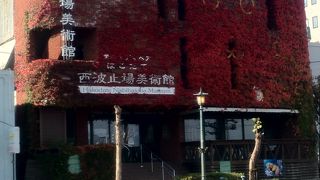 植物で覆われた外観とその前のオシャレな電燈が残る