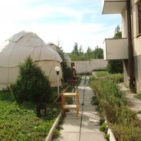 屋外のユルタと建物（右端）