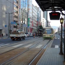 電停のプラットホームと入線する電車