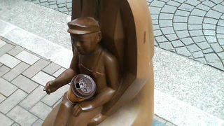 そっと我が子を膝に抱える母の愛情の像