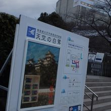入口付近にある説明看板。右奥が修理工事中の大天守。