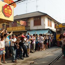 観光客が待ちかまえる中を列車が徐行する。