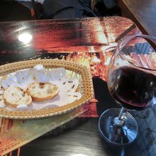 薄い小さいバゲットとサービスの赤ワイン。