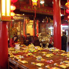 寺院内のお供え物と、参拝風景です