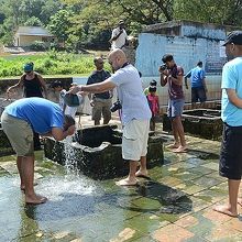 温泉井戸からお湯を汲んでは、お互いの体に掛け合う観光客。