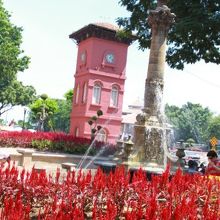 赤い花に映える時計台