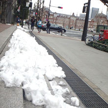 歩道横に残る雪ごしに駅舎