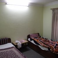 ベッドが2つとテーブルと椅子、クローゼット、扇風機など