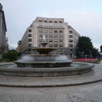 広場中心の噴水越しに