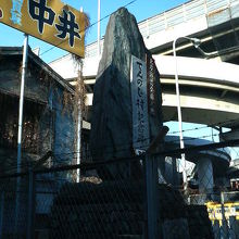 高速道路のガード下に石碑が建っています。