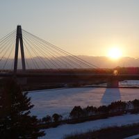 部屋から十勝川越しの夕日を望む