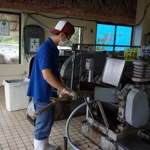 圧搾機にさとうきびを入れて搾ります