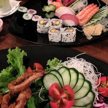 刺身と寿司の盛り合わせと、イカリング添えの野菜サラダ。