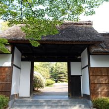 青もみじと茅葺門。この奥に素晴らしい景観が広がっています。