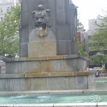 碑の基部で四方に水を噴く獅子の様子