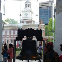 独立記念館が自由の鐘のうしろのガラスを通して見えます。