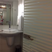 バスルームの入口は透明ガラスに白のストライプでお洒落。