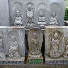 本堂手前の観音塔。左手後の巽堂で熱心にお参りする女性。