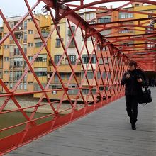 赤い鉄の格子向こうに見える民家も絵になる橋