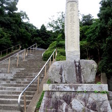 道に面して公園へ上がる」階段と駐車場がある