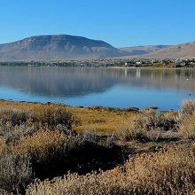 朝のレドンダ湾の水面に映るエル・カラファテの町や風景。