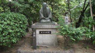 茂みの中で人に話し掛けるように座っています