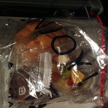 往路軽食：ロールパンにハムがサンドされたのとフルーツカップ