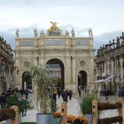 金色に装飾された門と建物の上に飾られた彫刻に取り囲まれたた広場です