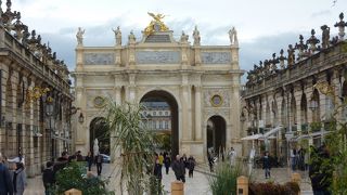 金色に装飾された門と建物の上に飾られた彫刻に取り囲まれたた広場です