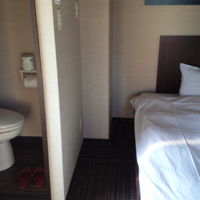 ベッドの真横にトイレ。トイレのドアは横開き