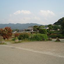 田んぼの向こうのちょっとした丘の手前に有ります。