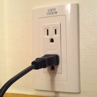 部屋の100V電源。海外仕様になっていないデジカメを充電中。