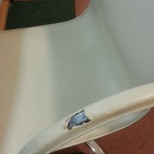 椅子の肘掛が机にあたって破れています