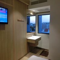壁掛けテレビと狭い洗面台、小さな窓