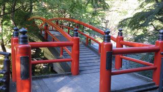 湯元近くにある赤い欄干の橋。温泉が流れている川の色にも注目