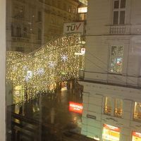 クリスマスシーズンで通りのイルミネーションが部屋の窓から楽し