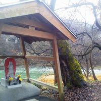 敷地内にある不動明王、その裏を信濃川が静かに流れています