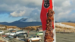 草千里グリーンパークで阿蘇山をバックに熊本名物馬刺串焼をいただく