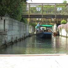 石垣で整備された水路を行く。上には十二橋の一つ。