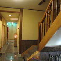 ２階に上がる階段の下にフロントがあります。奥にお風呂がありま